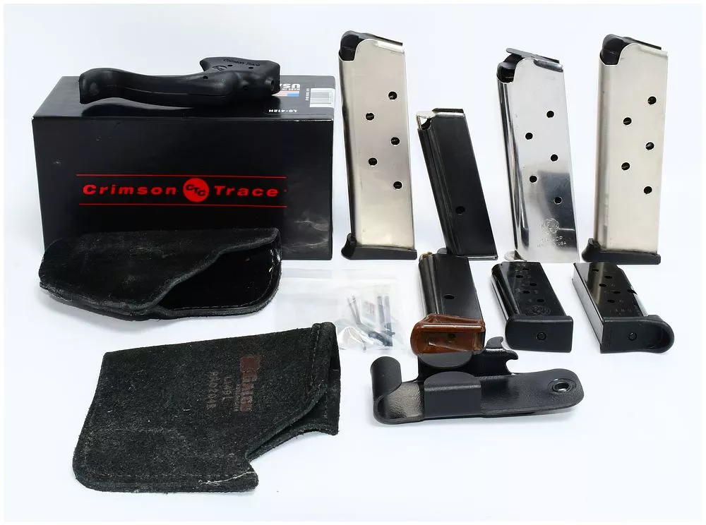 A Collection of Modern Firearm Accessories, including a Crimson Trace LG-412H Laser Grip, Magazines, and Holsters