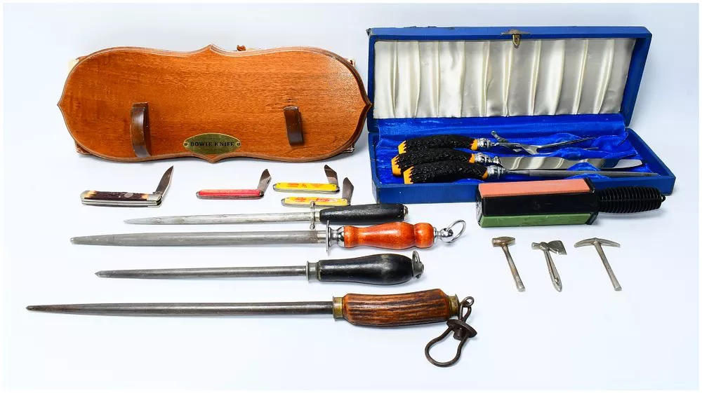 A Collection of Pocket Knives, Sharpening Steels, and a Cased Carving Set, including Coca-Cola Branded Examples and a 'Bowie Knife' Plaque
